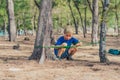 Camping people outdoor lifestyle tourists in summer forest near lazur sea. Blond serious boy in blue t-shirt study