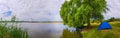 Camping on the side of the lake - lake panorama - fishing next to a willow tree landscape Royalty Free Stock Photo