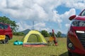 Camping site on grass field with tent and car beside tent. Leisure activity Royalty Free Stock Photo