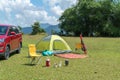 Camping site on grass field with tent and car beside tent. Leisure activity Royalty Free Stock Photo