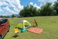 Camping site on grass field with tent and car beside tent. Leisure activity Royalty Free Stock Photo