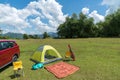 Camping site on grass field with tent and car beside tent. Leisure activity Royalty Free Stock Photo