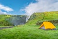 Camping site with tents in front of famous Skogarfoss waterfall, while hiking in Iceland, summer Royalty Free Stock Photo