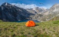 Camping on a summer green high-altitude plateau. Panoramic view of a blue mountain lake in the Altai with tent on the shore. Royalty Free Stock Photo