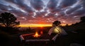 Camping at Sunset Tent, Campfire, and Dramatic Sky Royalty Free Stock Photo