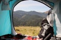 Camping tent with backpack and thermos in mountains on sunny day, view from inside Royalty Free Stock Photo
