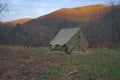 Camping tent in the Blue Ridge Mountains in Asheville, North Carolina. Outdoor lifestyle with axe, cast iron skillet, flannel blan Royalty Free Stock Photo