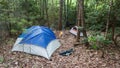 Camping tent in the Blue Ridge Mountains in Asheville, North Carolina. Outdoor lifestyle with axe, cast iron skillet, flannel blan Royalty Free Stock Photo