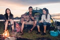 Camping tent camp in nature happy friends group night party bonfire and playing guitar together Royalty Free Stock Photo