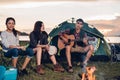 Camping tent camp in nature happy friends group night party bonfire and playing guitar together Royalty Free Stock Photo