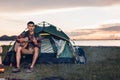 Camping tent camp in nature happy friends group night party bonfire and playing guitar together Royalty Free Stock Photo