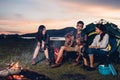 Camping tent camp in nature happy friends group night party bonfire and playing guitar together Royalty Free Stock Photo