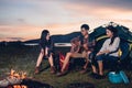 Camping tent camp in nature happy friends group night party bonfire and playing guitar together Royalty Free Stock Photo