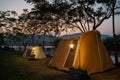 Camping tent on campsite with panoramic view in evening sunset. cozy tents for recreation near lake. people outdoors activity