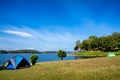 The camping tent is beside the lake and big tree in on sunny day Royalty Free Stock Photo