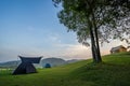 Camping and tent on Lawn or green grass ground in morning, vacation picnic on holiday relax, Camping season, sky and mountains