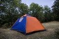 Camping and tent near the forest in could sky, Mountains of Caucasus Azerbaijan. Orange blue tent Royalty Free Stock Photo