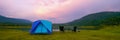 Camping Tent Near the Natural Lake and Mountain View with Outdoor Gear, Rustic Lantern on Table and Camping Chairs, Babeque grill