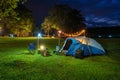 Camping tent and outdoor kitchen equipment at night in the park