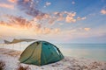 Camping tent on a quiet beach near the water, sunset sky, summer camp Royalty Free Stock Photo