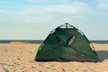 Camping and tent on sandy seashore. Vacation at sea with tent