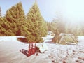 Camping in tent in winter forest. Snowshoes trek in mountains