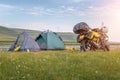 Camping tents and traveling motorcycle on flower meadows in the morning