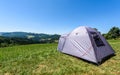 Camping tourist tent set up on meadow in the mountains. Small tent in green mountains of Slovenia