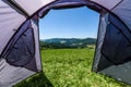Camping tourist tent set up on meadow in the mountains. Small tent in green mountains of Slovenia
