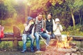 Happy family sitting on bench at camp fire Royalty Free Stock Photo