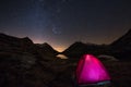 Camping under starry sky and Milky Way arc at high altitude on the italian french Alps. Glowing tent in the foreground. Adventure Royalty Free Stock Photo