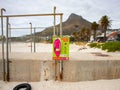 Colorful pink rescue buoy attached to a light green sign.