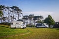 Campsite for campervans. Vans on the parking lot surronded by nature.