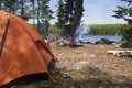 Campsite with orange tent and campfire on a northern Minnesota lake Royalty Free Stock Photo