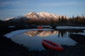 Campsite with orange tent and canoe on a lake