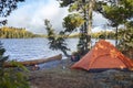 Campsite with orange tent on northern Minnesota lake during autumn