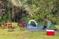 Campsite in tropical forest with two tents, chairs, table, food and drinks and cooler Royalty Free Stock Photo