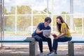 On a campus, a couple of students are studying together, and a teenager sits on a seat beside a sports court with a book Royalty Free Stock Photo