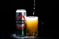 Can of Beck`s or Becks beer and beer glass on dark background. Illustrative editorial photo shot in Bucharest, Romania, 2021