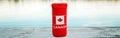 Can of beer in red cozy beer can cooler with Canadian flag standing on wooden pier by lake outdoor. Celebrating Canada Day