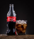 Can, bottle and glass of Coca-Cola with ice on wooden background Royalty Free Stock Photo