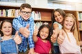 We can do it. Portrait of a group of cheerful young school children showing thumbs up at the camera inside a classroom Royalty Free Stock Photo