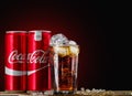 Can and glass of Coca-Cola with ice on wooden background. Royalty Free Stock Photo