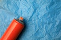 Can of graffiti spray paint on light blue crumpled paper, top view. Space for text Royalty Free Stock Photo