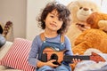 Can I play for you. Shot of a little boy playing the guitar while sitting at home. Royalty Free Stock Photo