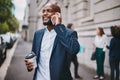 We can meet up after my meeting later. a businessman using his cellphone while out in the city. Royalty Free Stock Photo