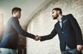 They can network like its nobodys business. two young businessmen shaking hands in a modern office.