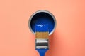 Can of paint and brush on orange background. Color of the year 2020 Classic blue Royalty Free Stock Photo