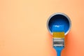 Can of paint and brush on orange background, top view. Color of the year 2020 Classic blue Royalty Free Stock Photo