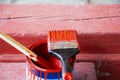 a can of red paint and a brush stained with paint. Painting works. Royalty Free Stock Photo